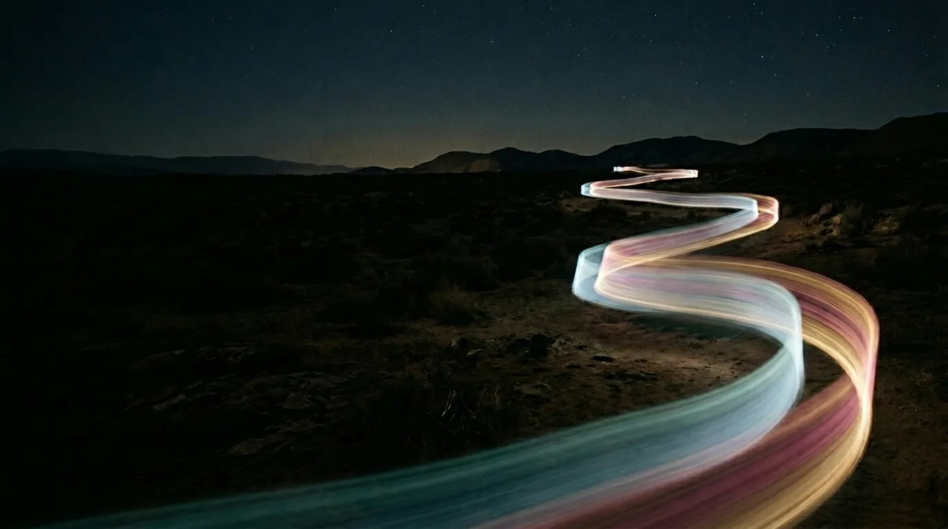 A flowing path of warm light moving across a dark landscape